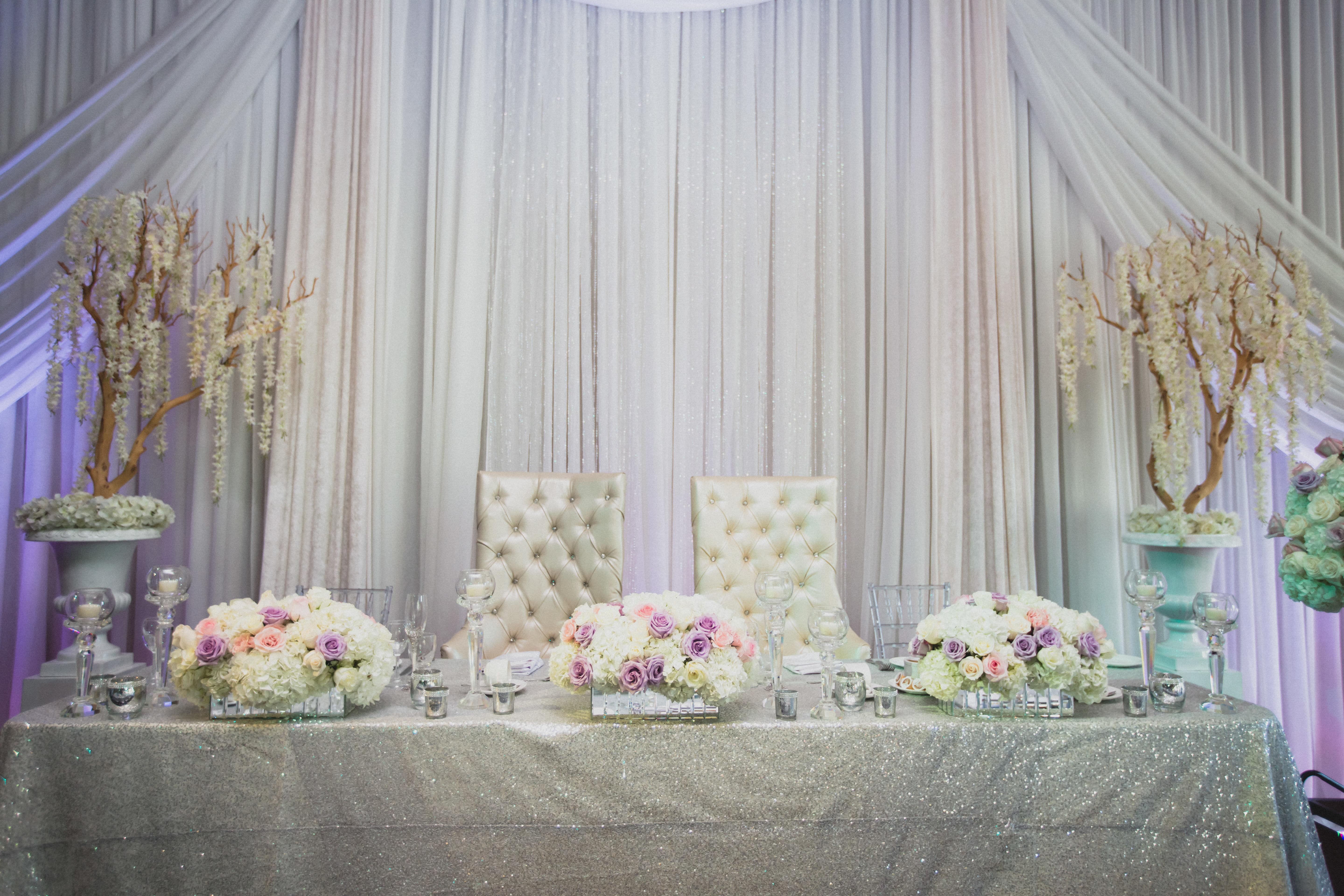 silver sweetheart table with floral arrangements
