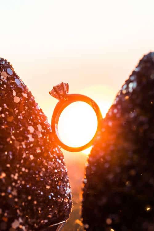 ring in between glittery accents with sunset in the background